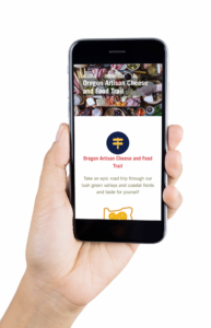 Hand holding a smartphone, displaying how the Oregon Cheese Guild website displays on mobile
